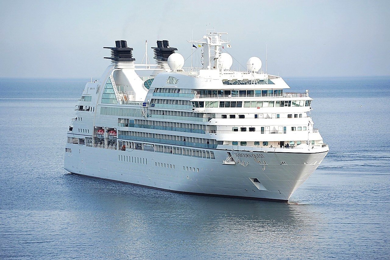 Navio de cruzeiro visto de lado, navegando em mar calmo